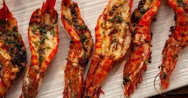 Baked garlic prawns with roasted peppers & gremolata toasts Recipe